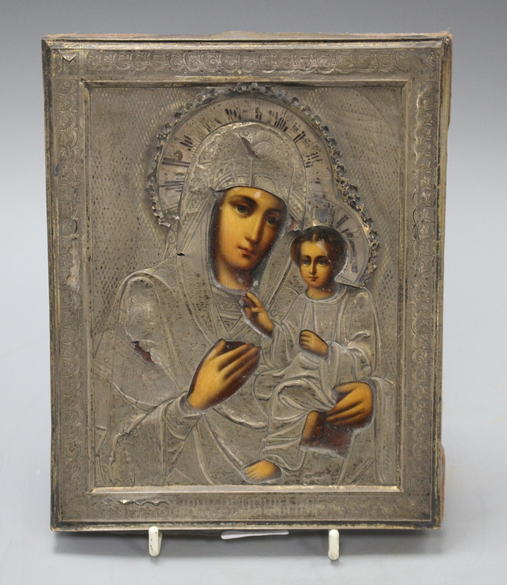 A Russian white metal overlaid tempera on panel icon, depicting the Virgin Mary and Christ child, 22 x 18cm